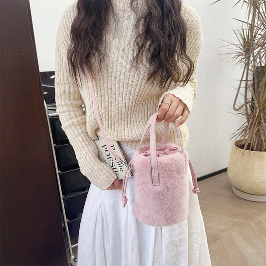 Sac seau fausse fourrure rose femme tendance été 2026 porté à la main